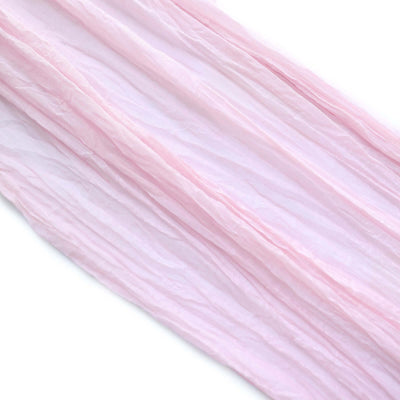 Crinkled pink fabric draped elegantly on a white background