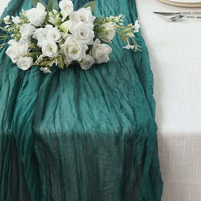 Teal table runner with white floral arrangement for elegant dining decor.