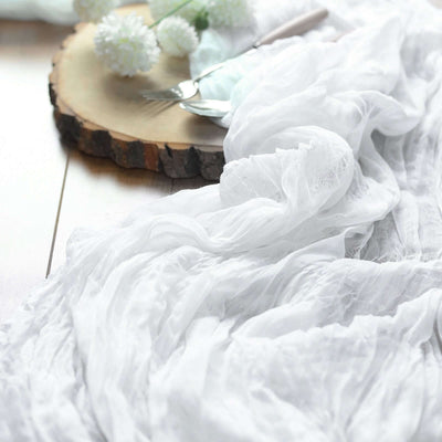 White textured fabric draped on a wooden surface with decorative elements.