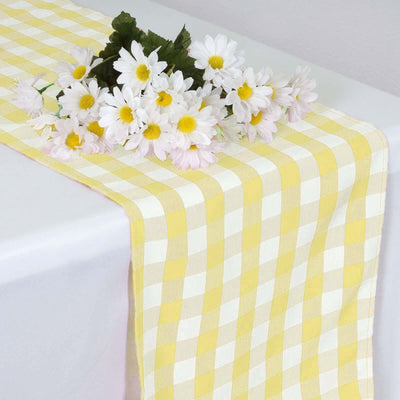 Yellow checked table runner with daisies on top.