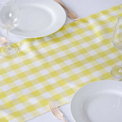 Yellow gingham table runner on a white table with plates and glasses