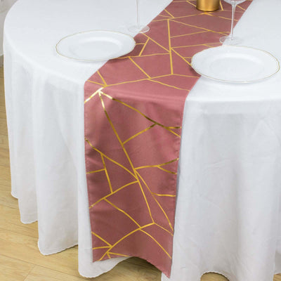 Geometric gold and burgundy table runner on a white table setting.
