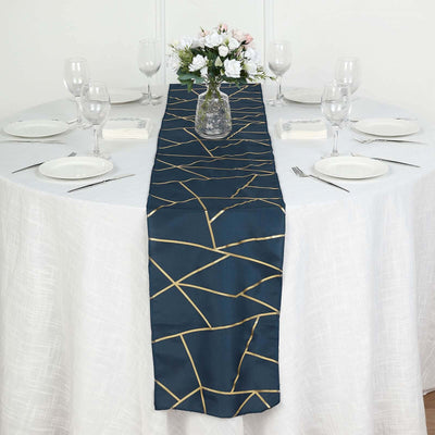 Navy table runner with gold geometric design on a dining table setting.