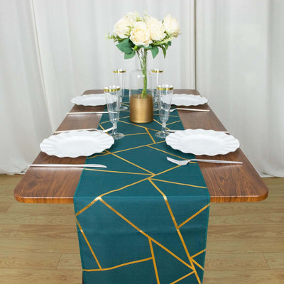 Teal geometric table runner on wooden table with white plates and floral centerpiece.