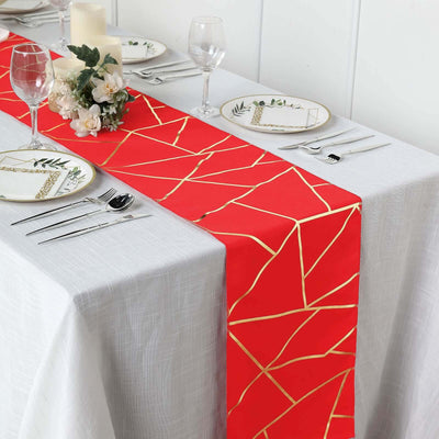 Red table runner with gold geometric design on a dining table setup.