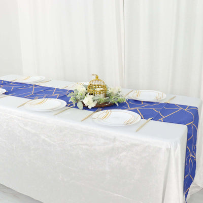 Elegant blue and gold table runner on a white table setting with plates and decor.