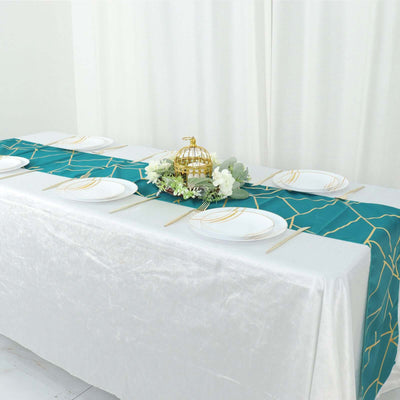 Teal table runner with gold geometric pattern on a white table setting.