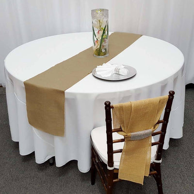Elegant burlap table runner on a round table with a floral centerpiece.