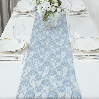 Blue lace table runner on a dining table set with glassware and floral centerpiece.
