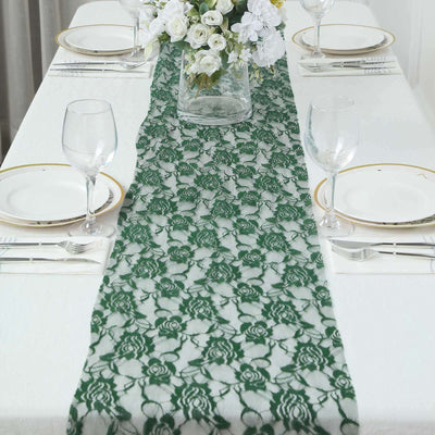 Green lace table runner on a dining table set with plates and glasses.