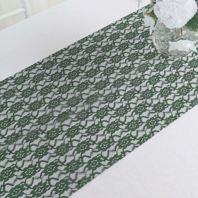 Green lace table runner on a white table with a decorative vase.
