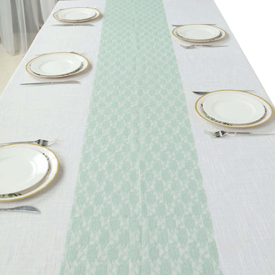 Mint green table runner on a white table setting with plates and cutlery.
