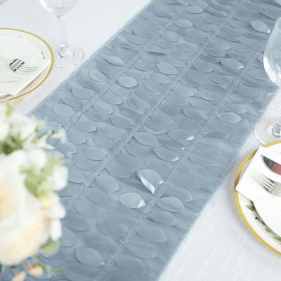 Gray table runner with leaf pattern on a dining table setting.