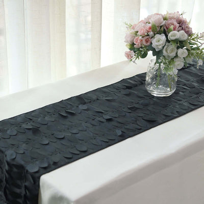 Black satin table runner with textured design, elegantly set with a floral arrangement.