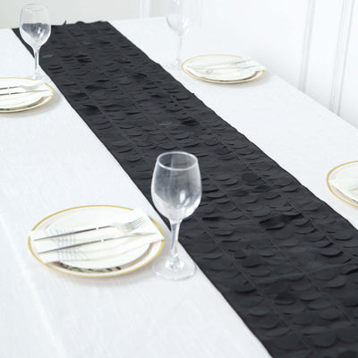 Black table runner on a white table setting with plates and glassware.