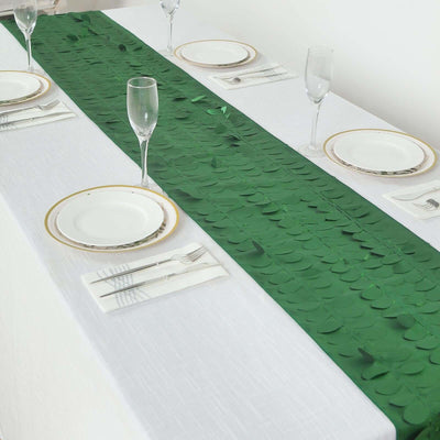 Green table runner with leaf accents on a dining table setting.