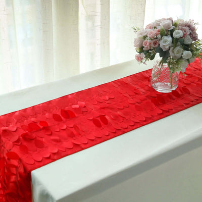 Red table runner on a white table with a vase of flowers.