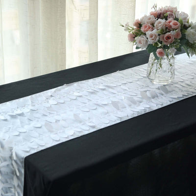 Decorative table runner on a black table with a vase of flowers.