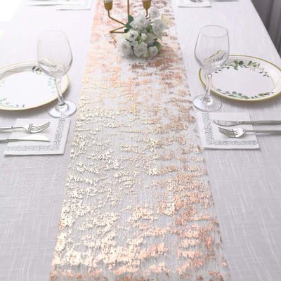Elegant table runner with rose gold accents on a white table setting.