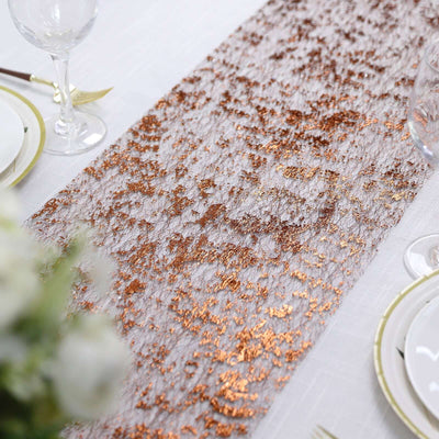 Rose gold lace table runner on a dining table setting.