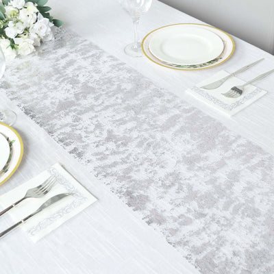 Elegant silver and white table runner on a dining table setting.
