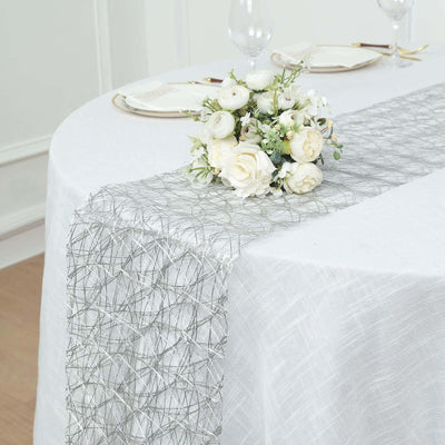 Elegant silver table runner with floral centerpiece on a white table.