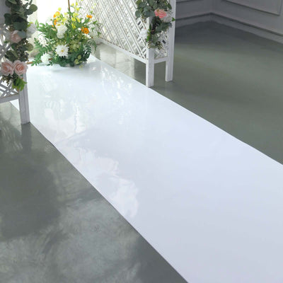 White glossy event aisle runner with floral decor on the side.