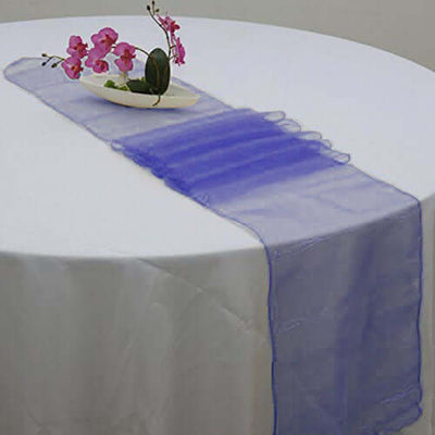 Purple table runner draped elegantly on a white table with decorative flowers.