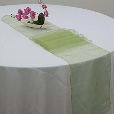 Green table runner with ruffled edges and decorative flowers.