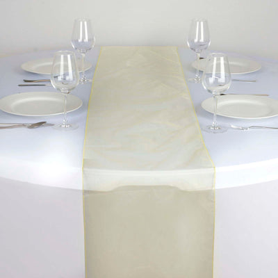 Elegant sheer table runner in soft gold on a round table setting.