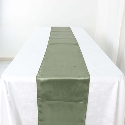 Olive green satin table runner on a white tablecloth