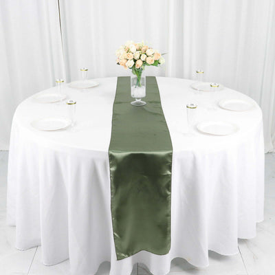 Elegant green satin table runner on a round white table with floral centerpiece.