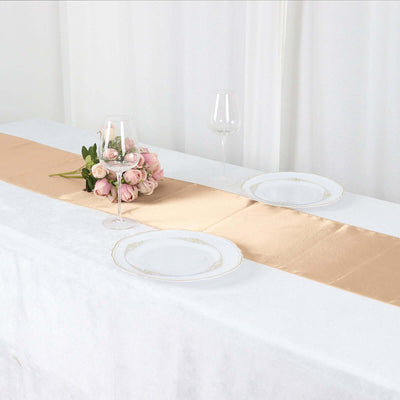 Elegant table setting with gold runner, plates, and floral centerpiece.