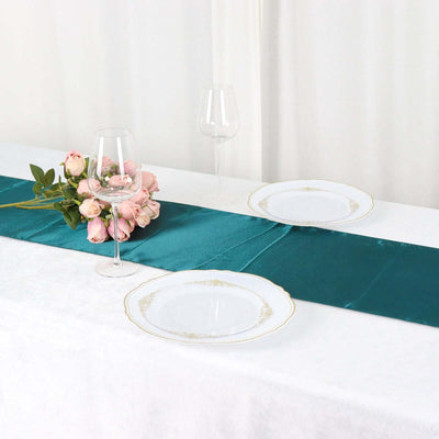 Elegant table setting with teal runner, white plates, and floral arrangement.