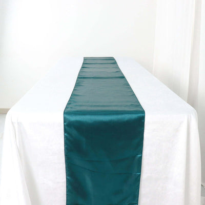 Teal satin table runner on a white tablecloth