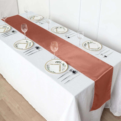 Rustic table setting with a copper satin runner and elegant dishware.