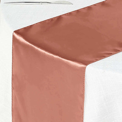 Copper satin table runner draped elegantly on a white tablecloth.