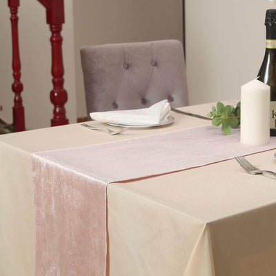 Elegant table setting with pink runner, candle, and wine bottle.