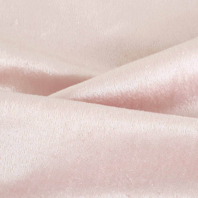 Soft pink velvet fabric texture close-up.