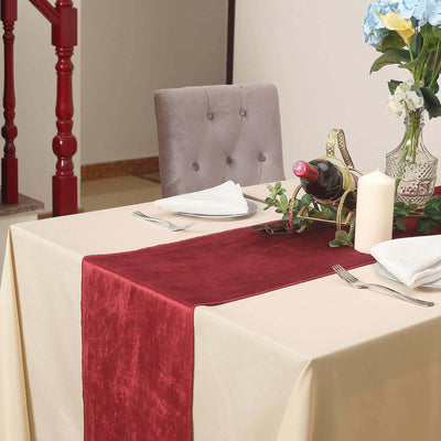 Elegant table setting with wine, flowers, and decorative runner.