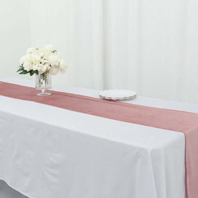 Blush pink table runner on a white table with flowers and plate