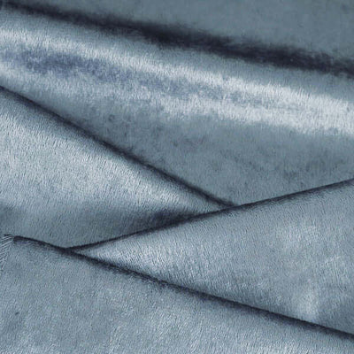 Luxurious blue velvet fabric texture close-up for upholstery and fashion.
