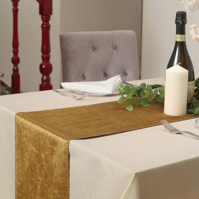 Elegant gold table runner on a dining table with candles and decor.