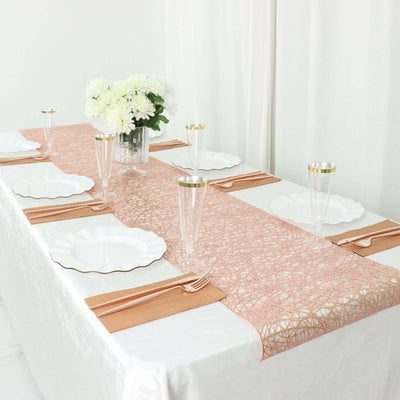 Elegant table setting with pink lace runner, white plates, and floral centerpiece.
