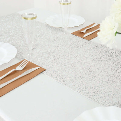 Elegant white table runner with geometric design, set on a dining table.