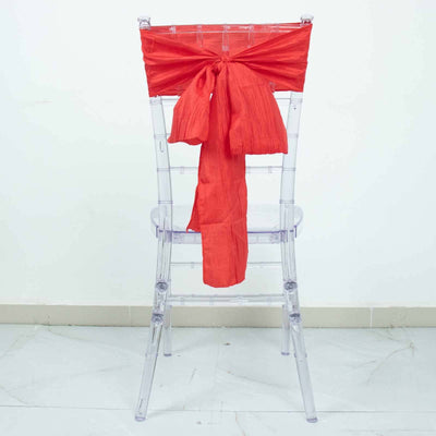 Transparent chair with a vibrant red sash tied at the back.