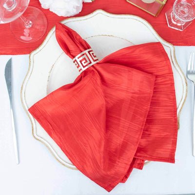 Red silk napkin elegantly arranged on a decorative plate.