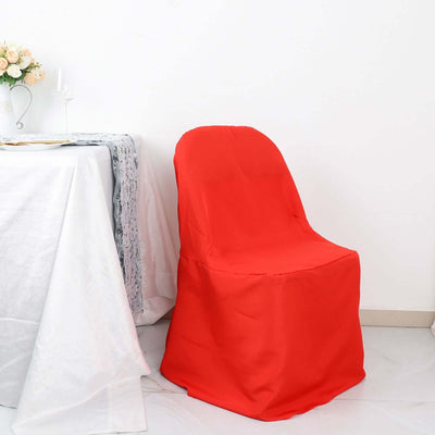 Red chair cover draped over a chair next to a table setting.