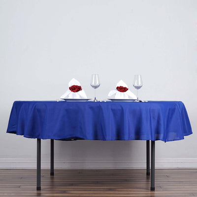 Elegant blue tablecloth with red rose centerpieces and glassware.