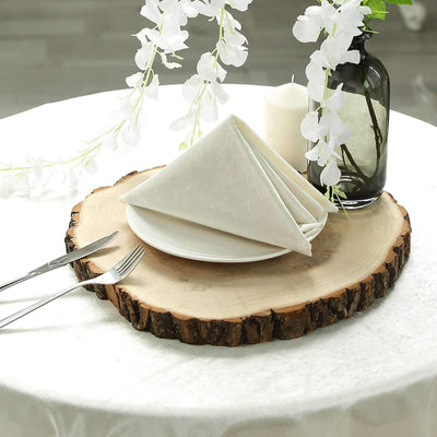 Elegant white napkin neatly folded on a rustic wooden table setting.